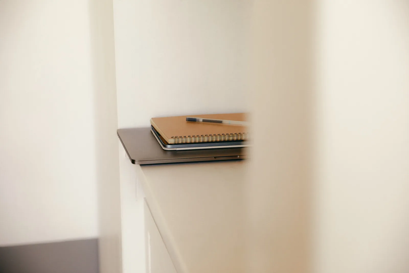 A laptop and notebook set down. A website project, handled